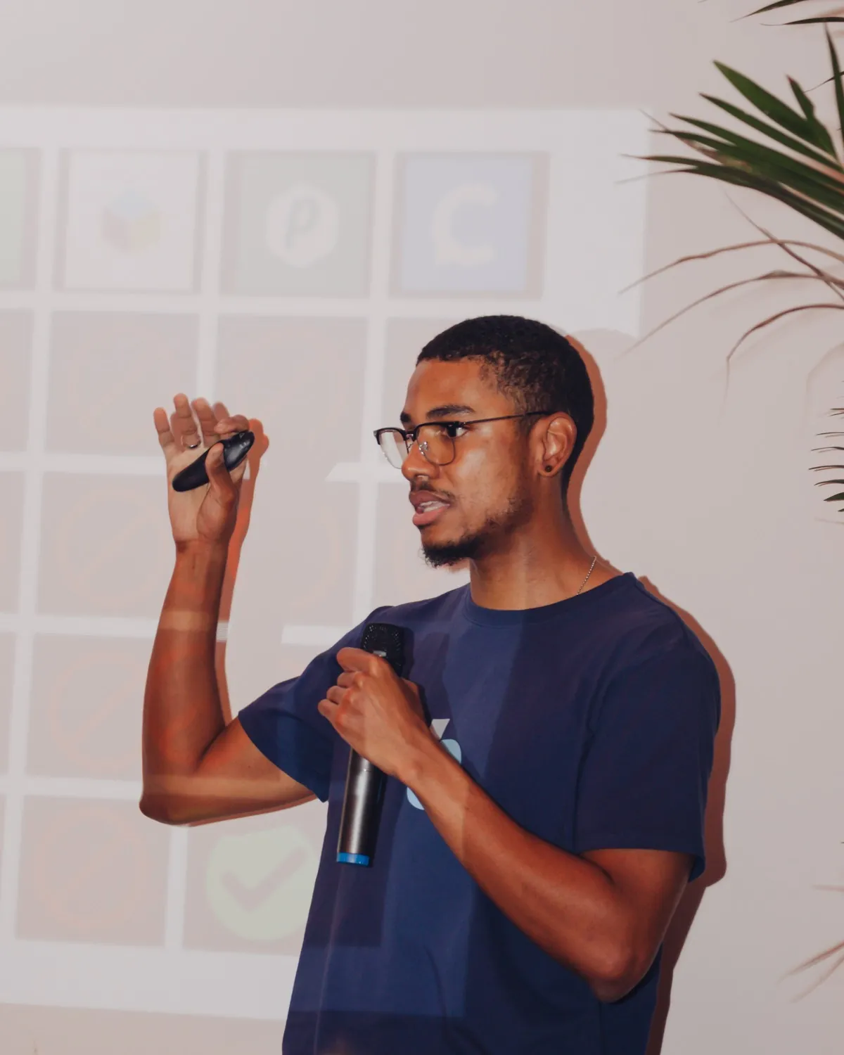 Marcos Lara presenting on stage, holding a microphone.